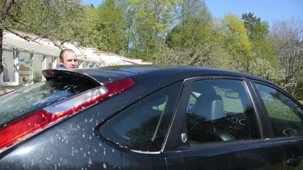 Man with sponge wash clean automobile car roof in garden yard — Stock Video