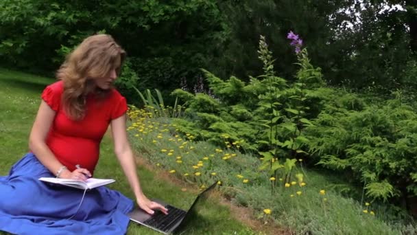 Pregnant business woman work with computer and write on notebook — Stock Video