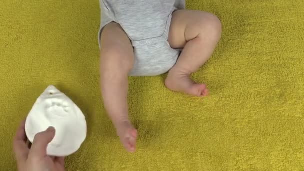 Mamma satte foten och palm mark nära nyfött barn — Stockvideo