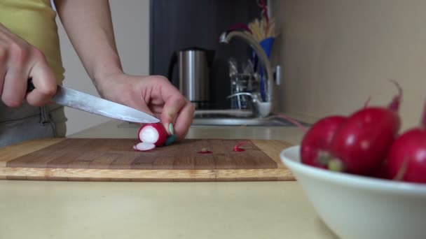 Mulher mão cortar legumes de rabanete na tábua de corte para salada. 4K — Vídeo de Stock