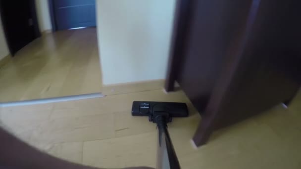 Stofzuiger hulpprogramma zuigen stof op houten vloer onder de kast. 4k — Stockvideo