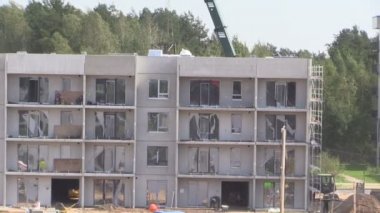 İnşaat alanında çalışır. İşçi ve Vinçler.