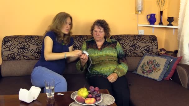 Frau zog Großmutter Blutmessgerät am Handgelenk an und wartete — Stockvideo