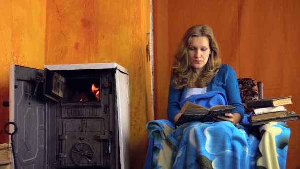 Femme lire livre à la maison près de poêle chaud cheminée le jour de l'hiver — Video