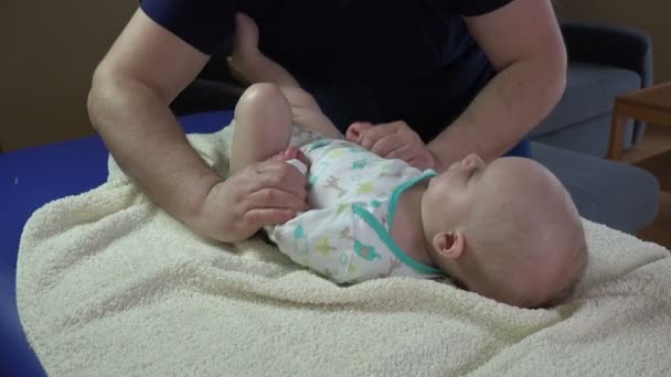 Ojciec z niemowlę noworodek robić specjalne ćwiczenia, masaże. 4k — Wideo stockowe
