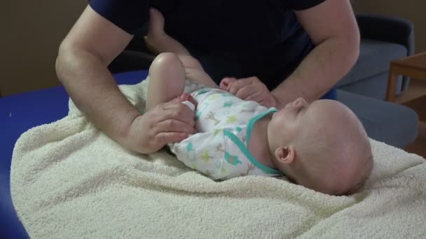 Père avec bébé faisant des exercices spéciaux, massage. 4K — Video