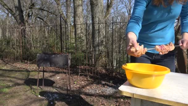 Femme main prendre de la viande épicée crue et mettre sur la broche en métal. 4K — Video