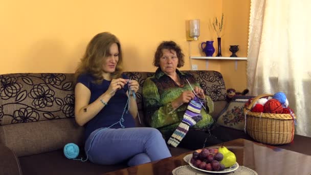 Grandma knitting stockings with pregnant granddaughter on sofa — Stock Video