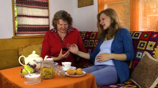 Gravid barnbarn kvinna ha roligt med mormor och telefon — Stockvideo