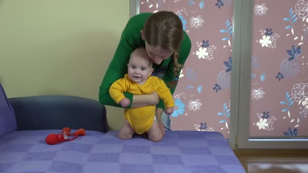 Vacker mor med baby pojke son gör stå upp övningar. 4k — Stockvideo