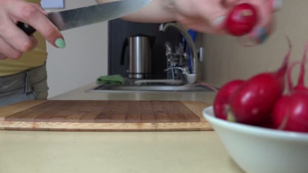 Kvinnlig hand skära rädisor grönsaker på skärbräda för sallad. 4K — Stockvideo