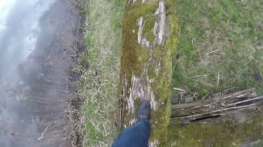 adam dere üzerinde yosunlu kütük düştü gidin. Kamera adam kafasında