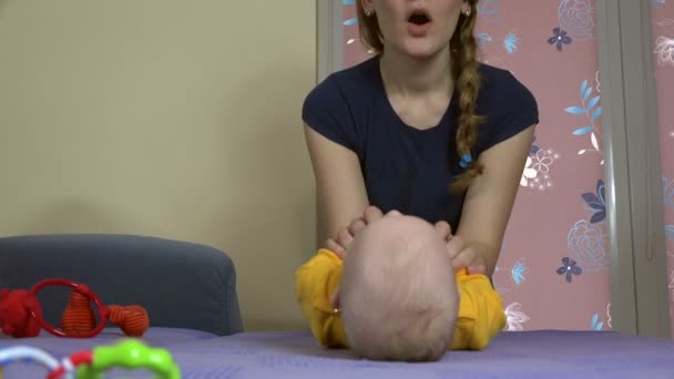 Tender vrouw met schattige baby maken sit-up oefeningen op de Bank. 4k — Stockvideo