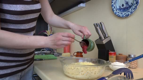 Las manos femeninas ponen salsa roja en la pasta de espagueti. 4K — Vídeos de Stock