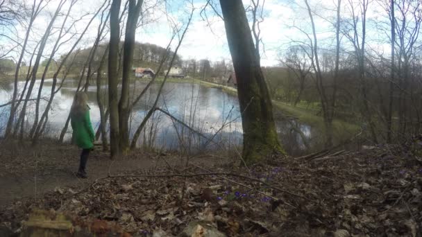 Woman walk through forest park path. Lake,houses, sky. 4K — Stock Video