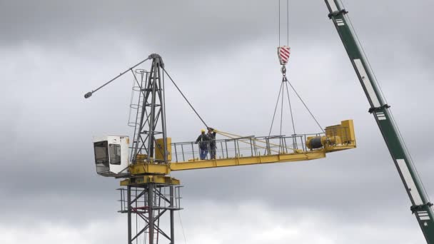 Werknemers monteren kraan op bewolkte hemelachtergrond. 4k — Stockvideo