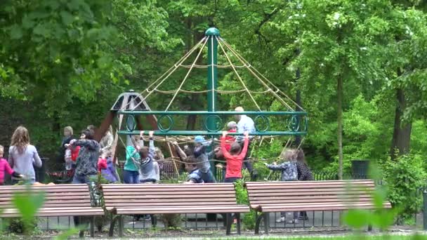 Kinderen kinderen rijden op rotonde in de speeltuin. 4k — Stockvideo