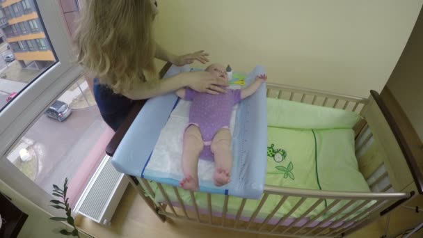 Mère lubrifier le visage du bébé avec de la crème dans la chambre. 4K — Video