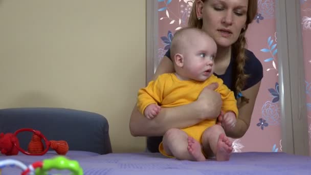 Χαμογελαστή γυναίκα διδάσκει το μωρό να καθίσει μόνη της. 4K — Αρχείο Βίντεο