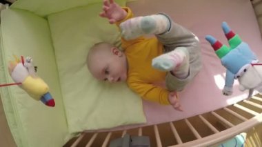 sevimli bebek dönen atlıkarınca oyuncak altında yatakta yalan. 4k