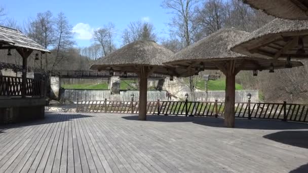 Persone in parco con cascata e pergolato di paglia — Video Stock