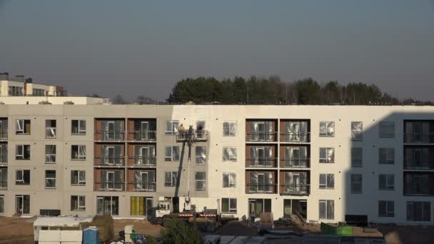 Constructeurs pulvériser nouvellement construire mur de la maison plate moderne en blanc. 4K — Video