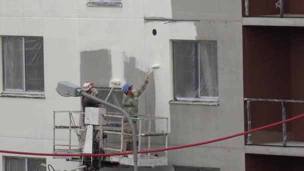 Bauarbeiter streichen neue moderne flache Hauswand mit Walze. 4k — Stockvideo