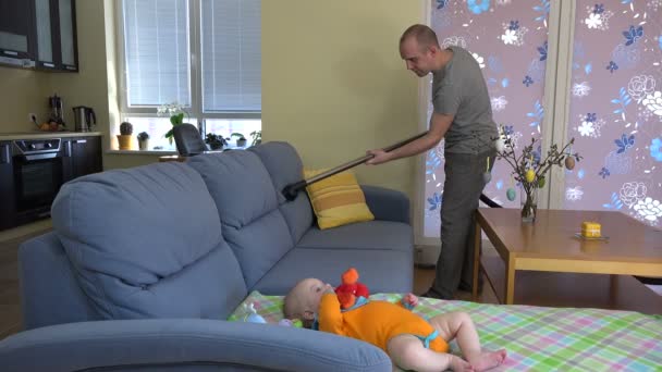 Far man hoover damm från soffa runt baby dotter. 4k — Stockvideo