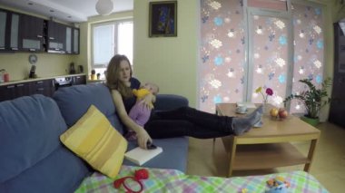 Hala küçük anne çocuk kucağında, öfkeyle cevap telefon. 4k