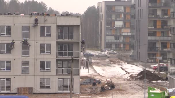 Wysoki wspinacz pracowników ocieplić dom ściany wspólne powiesić na lina — Wideo stockowe