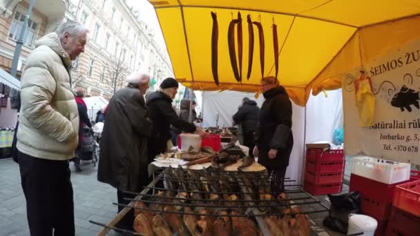 La gente compra pescado ahumado en el puesto del vendedor. Comida de la ciudad. 4K — Vídeo de stock