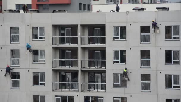 Risky construction site work. High wall insulation hang on rope — Stock Video