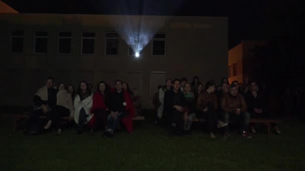 Young people watch open air screening cinema movie. 4K — Stock Video