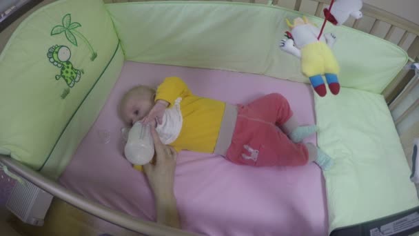 Mother hand feed newborn baby girl with milk powder bottle. 4K — Stock Video