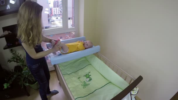 Madre vistiendo a su bebé con pantalones rosas. 4K — Vídeos de Stock