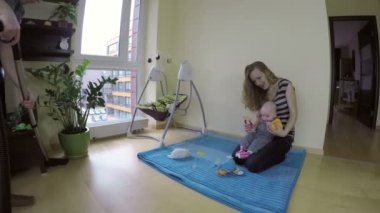 Anne ve baba hoover kat bebek ile oyna. Mutlu bir aile. 4k