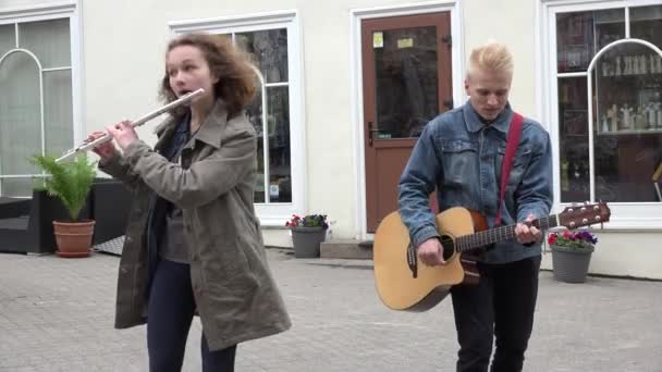 Músicos bonitos casal tocar guitarra, flauta e cantar ao ar livre. 4K — Vídeo de Stock