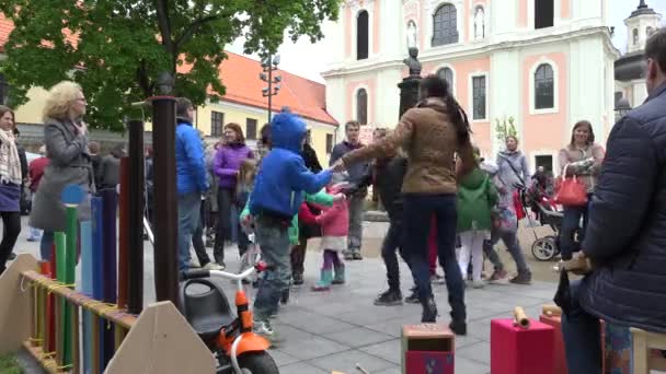 Niños tomados de la mano y bailando en parque cuadrado al aire libre — Vídeos de Stock