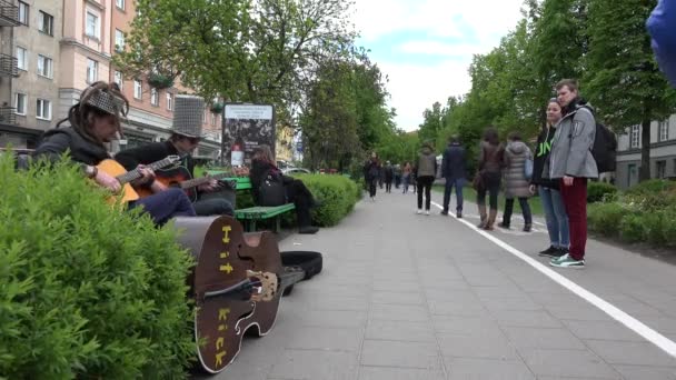 Guitarristas hombres virtuosos tocan melodías y la gente pasa por alto. 4K — Vídeo de stock