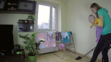 Bebek süpürge ile onun elleri temiz katta annesiyle. 4k