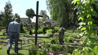 Genç adam torunu küçültmek büyükanne mezar yakınındaki üzüntü içinde. 4k