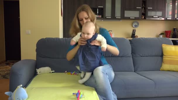 Frau mit Kind auf Sofa nimmt dem Familienoberhaupt Geld weg. 4k — Stockvideo