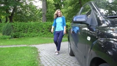 kadın arabanın kapısını açmak ve dışarı onun bebek bebek sit Emanet koltukta. 4k