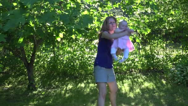 Actieve gelukkig moeder met babymeisje hebben plezier in de avond zon. 4k — Stockvideo