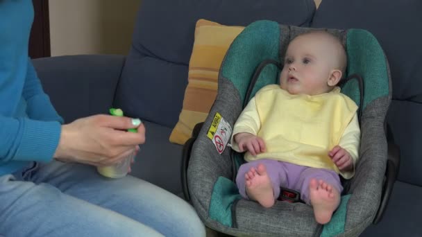 Baby flicka äter maten mosar från mor händer med sked. 4k — Stockvideo