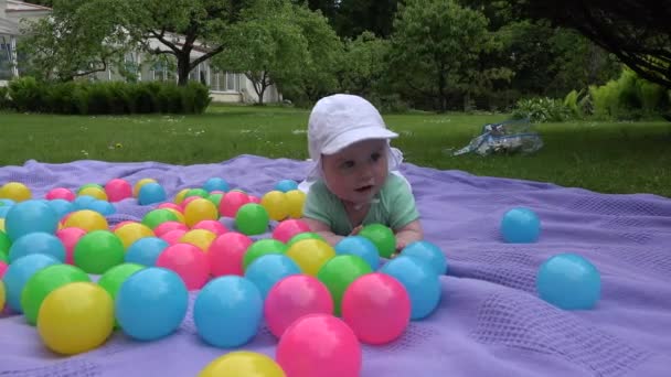 Kleine baby meisje spelen met kleurrijke bal outdoor in Park. — Stockvideo