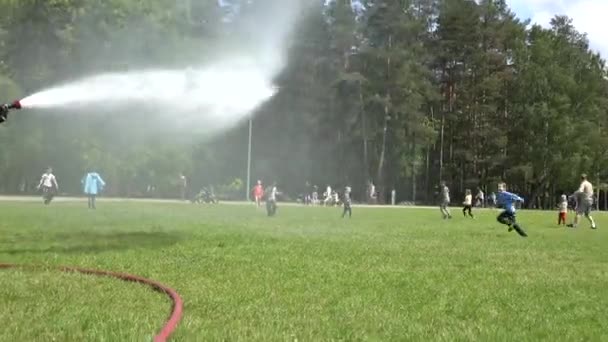 Bombero uso de agua manguera de entrenamiento en el parque — Vídeos de Stock