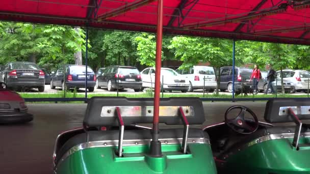 Padres con niños conducen parachoques esquivar coches. 4K — Vídeo de stock