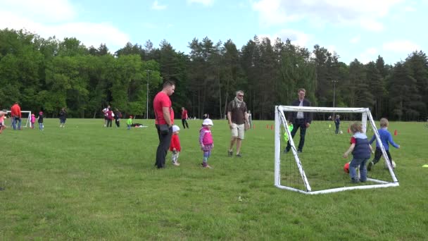 Föräldrar med barn spela fotboll fotboll i offentlig park. 4k — Stockvideo