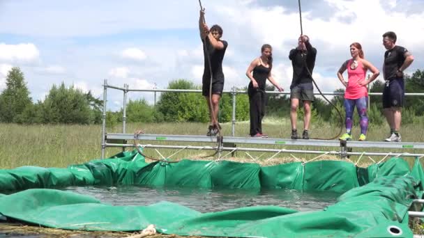 Sportsman with swing rope jump over water pool. 4K — Stock Video